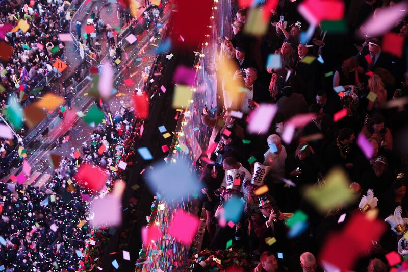 Revellers watch and record as confetti falls over Times Square (Heather Khalifa/AP)