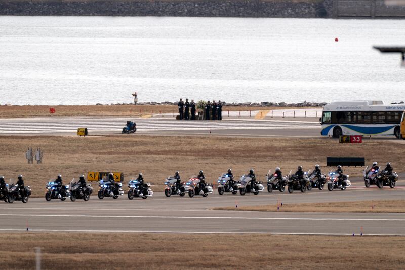 Police officers escort buses carrying family members of the victims (Jose Luis Magana/AP)