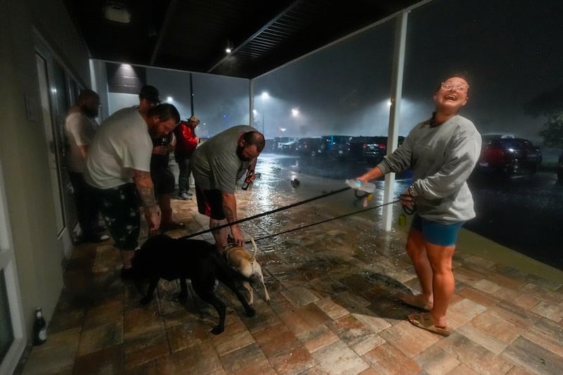 Amy Sapanara reacts as a group of tow truck drivers from Georgia greet her dogs outside the hotel where they are taking shelter during Hurricane Milton (Julio Cortez/AP)