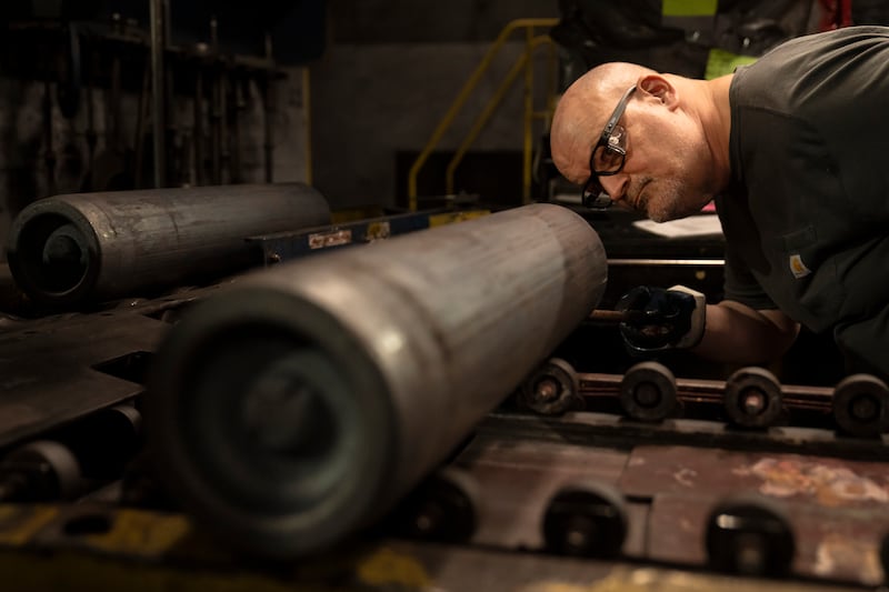 A steel worker inspects a 155mm M795 artillery projectile during the manufacturing process at the Scranton Army Ammunition Plant (Matt Rourke/AP)