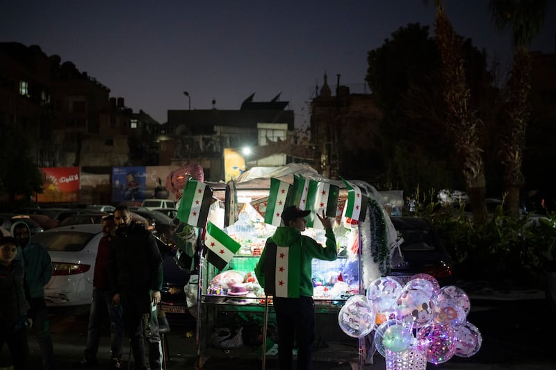 A street vendor flashes a victory sign in the Bab Touma neighborhood in the Old City of Damascus (Leo Correa/AP)