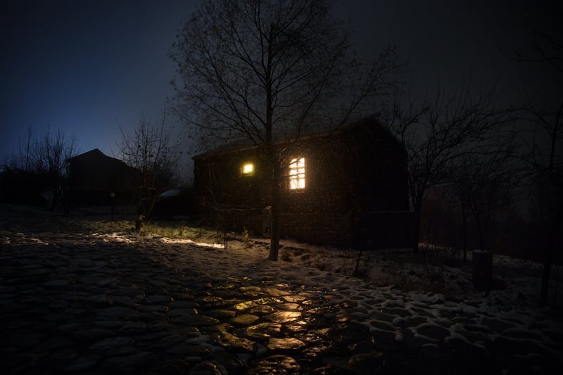 Wooden house in winter forest. Mountain house in the snow at night. Misty night. Long exposure shot