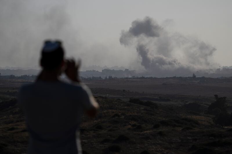 A man watches smoke rising to the sky after an explosion in the Gaza Strip (Leo Correa/AP)