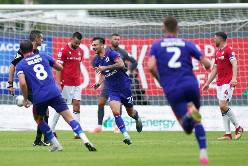 Daniel Harvie, centre, celebrates after scoring MK Dons' fifth goal at Wrexham