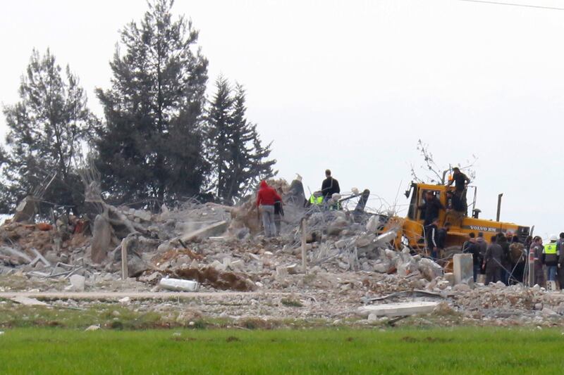 Civil defence workers at the site of a destroyed warehouse in Lebanon (AP)