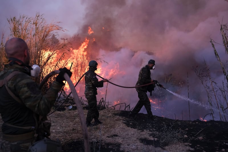 The wildfire raced through pine forests left tinder-dry by repeated heatwaves this summer (Aggelos Barai/AP)