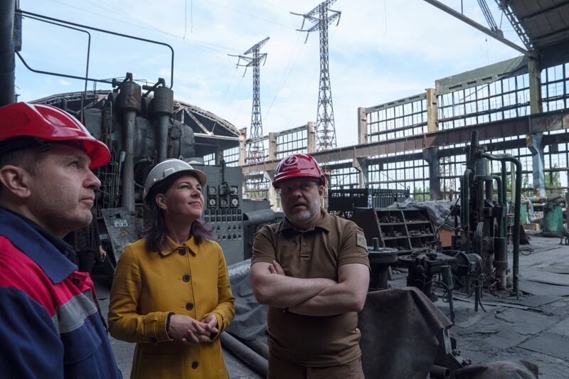 German foreign minister Annalena Baerbock speaks to Ukrainian energy minister Herman Halushchenko during an official visit to a thermal power plant which was damaged by a Russian rocket attack in Ukraine (Evgeniy Maloletka/AP)