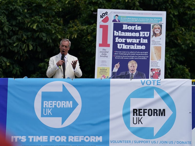 Reform UK leader Nigel Farage unveils the poster from the top deck of Reform UK’s battle bus while on the campaign trail in Maidstone, Kent