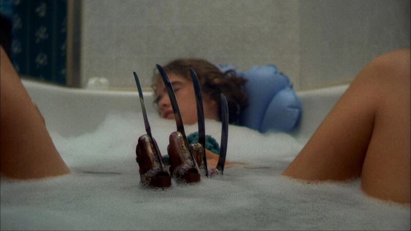 An iconic shot from A Nightmare on Elm Street showing Nancy (Heather Langenkamp) in the bath with Freddy Kruger's bladed glove emerging from the suds between her legs