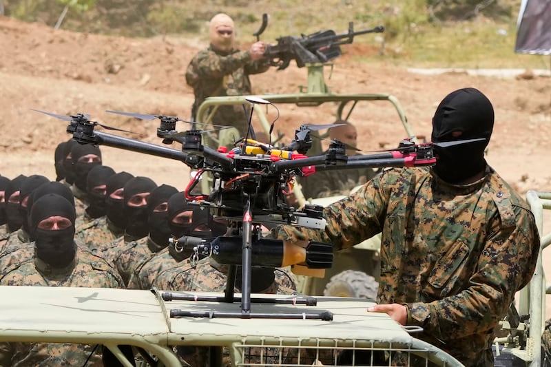 A Hezbollah fighter stands next to an armed drone during a training exercise in southern Lebanon in May 2023 (Hassan Ammar/AP)