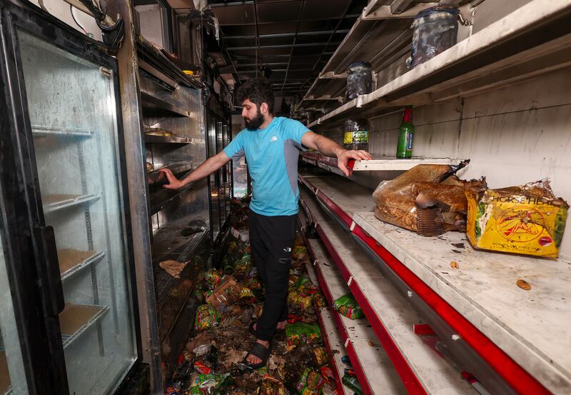 Supermarket worker Jamal Ghabes looks at the damaged after it was set alight for a second time. 
PICTURE COLM LENAGHAN