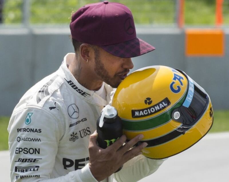 Lewis Hamilton holds the helmet of former Formula One driver Ayrton Senna