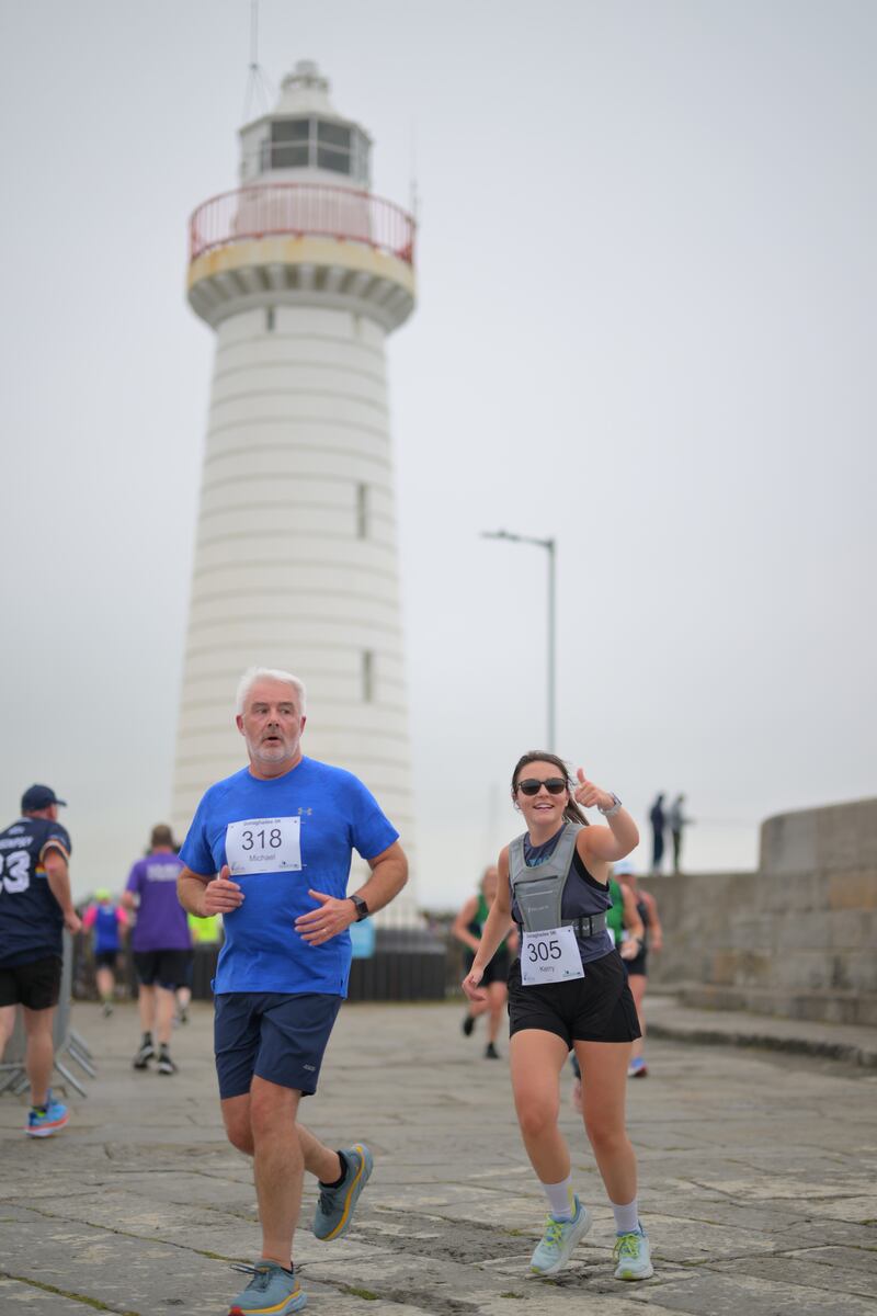 Group of runners in 5k race in front of white lighthouse