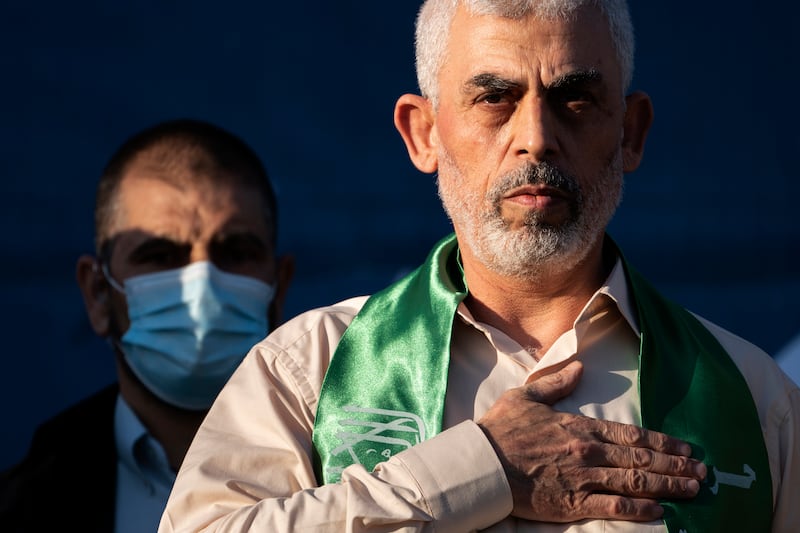 Yahya Sinwar, Palestinian leader of Hamas in the Gaza Strip, places his hand over his heart on stage after greeting supporters at a rally in May 2021 in Gaza City (John Minchillo/AP)