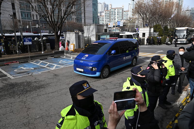 A blue van carrying impeached South Korean President Yoon Suk Yeol arrives at Seoul Western District Court (Kim Hong-ji/Pool Photo/AP)