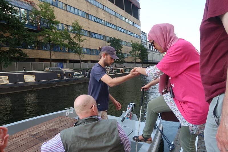 Man helping woman into boat