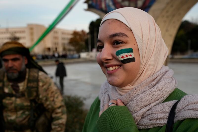 A Syrian girl with the revolutionary flag painted on her face celebrates during the second day of the takeover of the city by insurgents (Hussein Malla/AP)