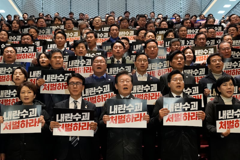 Democratic Party leader Lee Jae-myung, bottom centre, shout slogans during a press conference with his party members at the National Assembly in Seoul (Ahn Young-joon/AP)