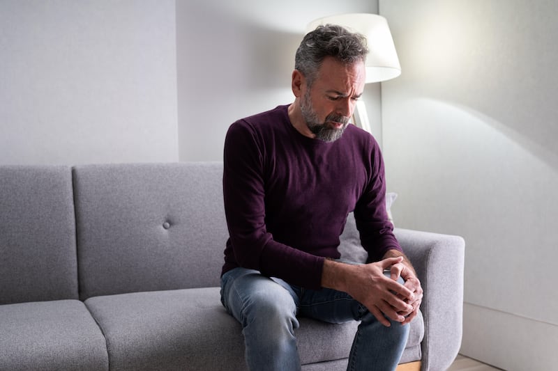 Mature man holding onto knee struggling with joint pains