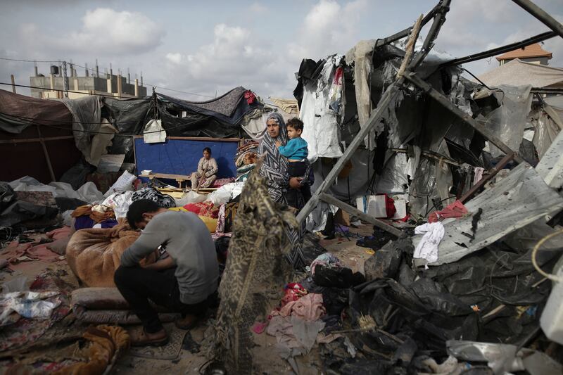 Displaced Palestinians inspect their tents destroyed by Israel’s bombardment of an UNRWA facility west of Rafah city (Jehad Alshrafi/AP)