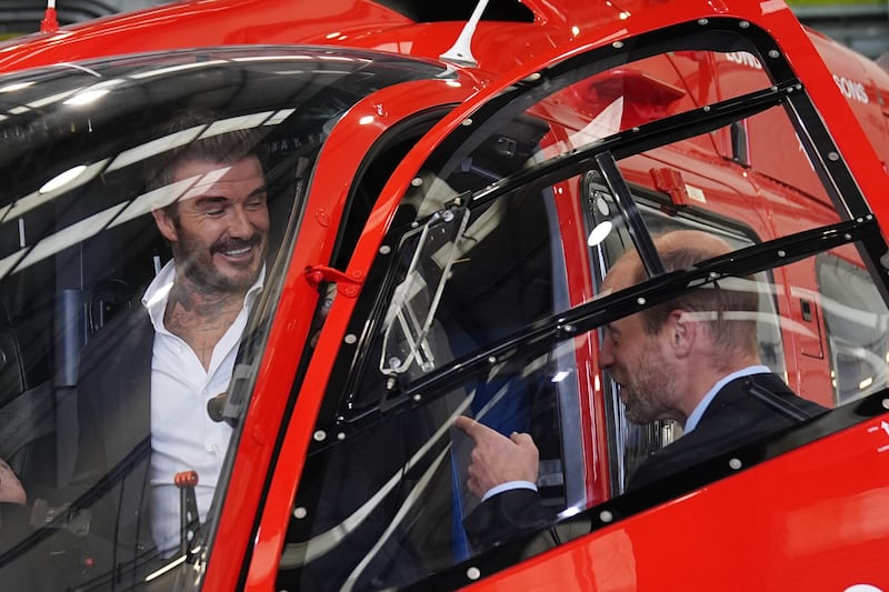 The Prince of Wales with David Beckham sitting in the cockpit of one of the new London Air Ambulance Charity helicopters