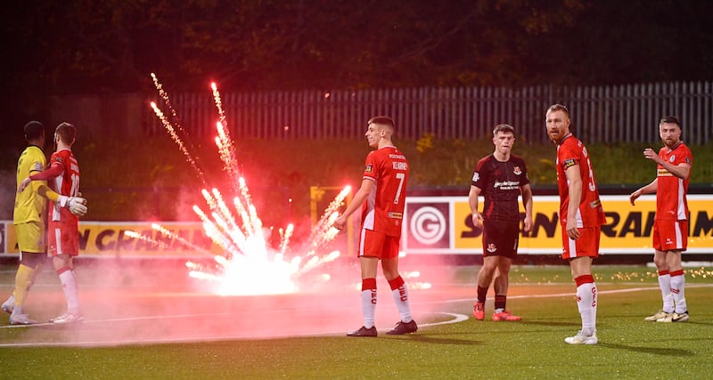 A firework goes off  beside Shea Kearney and Michael Newberry of Cliftonville at full time at this Evening’s game at Solitude, Belfast