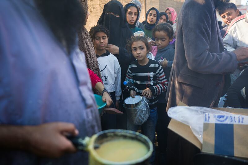 Palestinians queue for food in Deir al-Balah, Gaza Strip (Abdel Kareem Hana/AP)