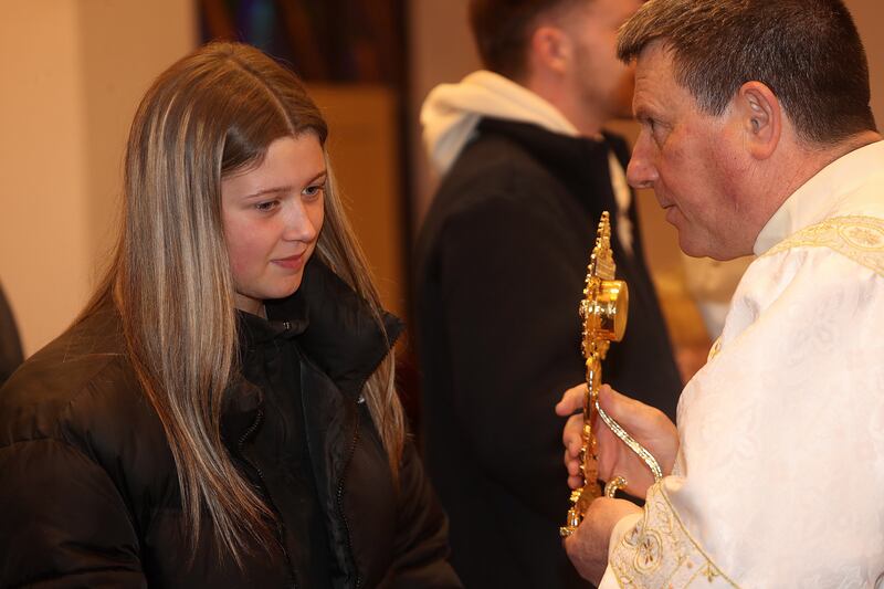 Zara Smith from Teconnaught receiving a blessing with the relic of Blessed Carlo Acutis from Deacon Jackie Breen in St Nicholas' Church in Ardglass, Co Down (Bill Smyth)