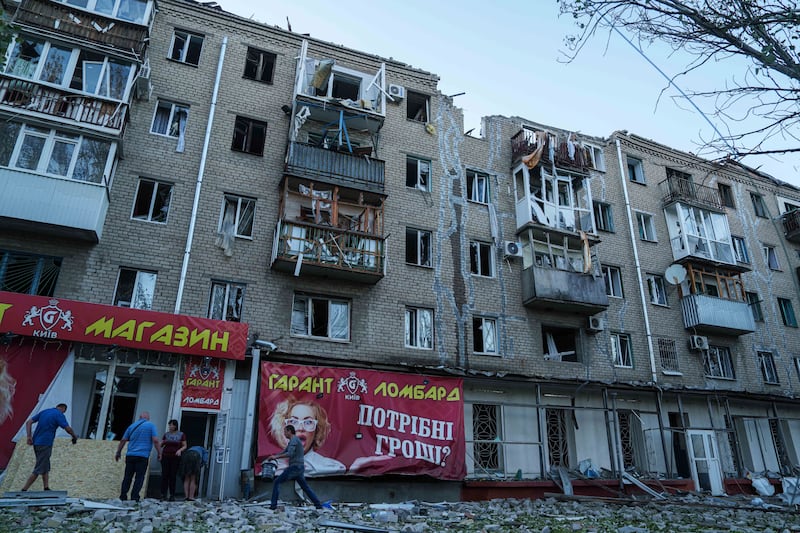 People clear the rubble in a front of a residential building heavily damaged in a Russian air strike in Kramatorsk, Donetsk region, Ukraine (Evgeniy Maloletka/AP)