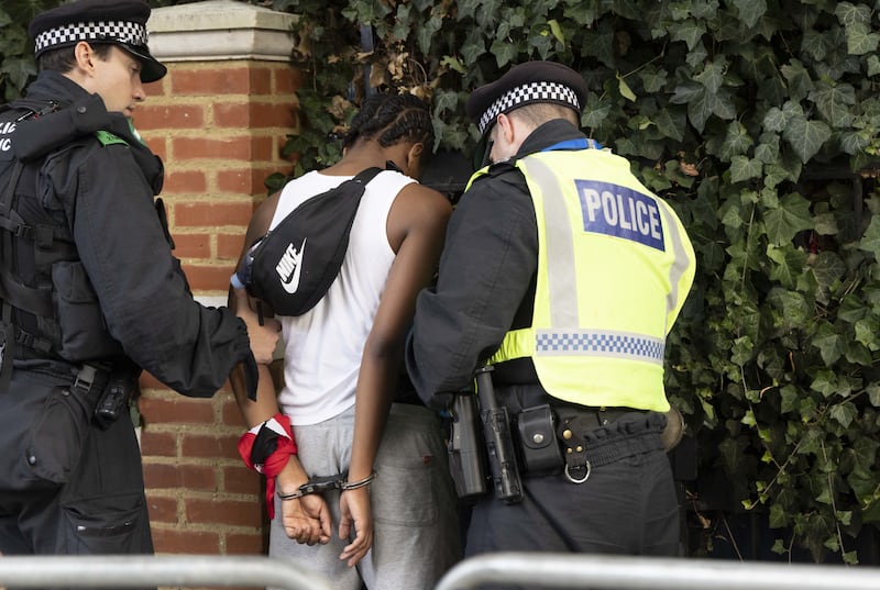 Police officers detain a man during the Notting Hill Carnival celebration.