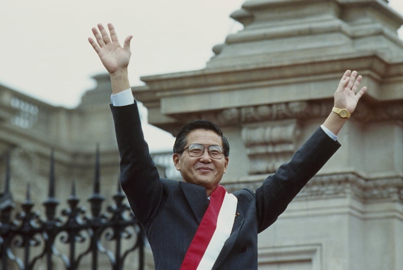 President Alberto Fujimori waves to supporters at the government palace in July 1990 after taking over the presidency (AP)