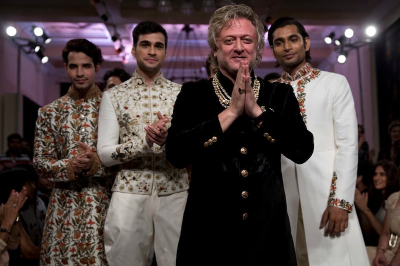 Rohit Bal next to models wearing his creations at the end of his show at the Couture Week 2016 in New Delhi in 2016 (Tsering Topgyal/AP)