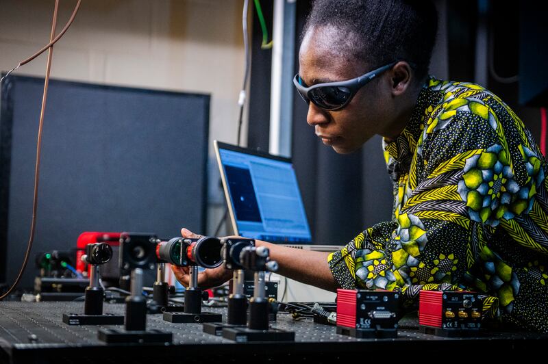 Dr Elizabeth Eso aligning an optical system to experimentally demonstrate a time-bin quantum key distribution system. .