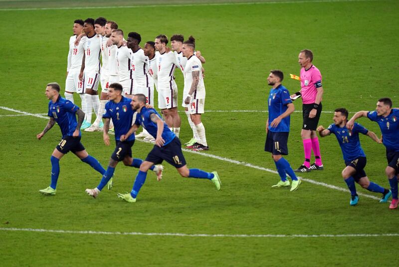 England players look on as Italy celebrate winning the Euro 2020 final on penalties