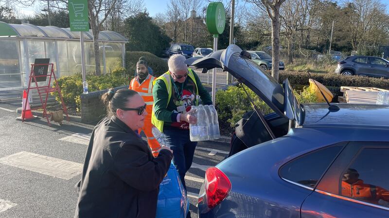 A helper loads a car at a bottle station at Asda, Totton