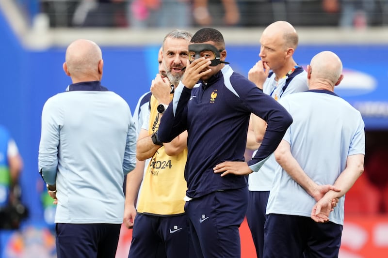 Kylian Mbappe, centre, wore a protective mask during the warm-up in Leipzig