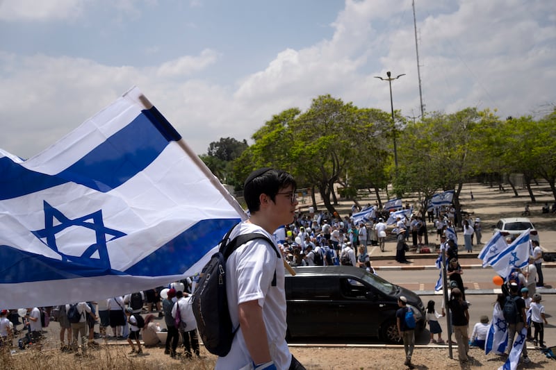 Thousands of Israelis march with national flags in the southern city of Sderot calling for Israel to reoccupy the Gaza Strip once the war is over (Maya Alleruzzo/AP)