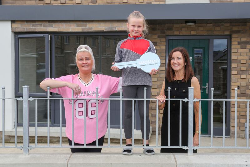 Residents pictured with Margaret Robinson, housing officer at Woven receiving the keys to their new home