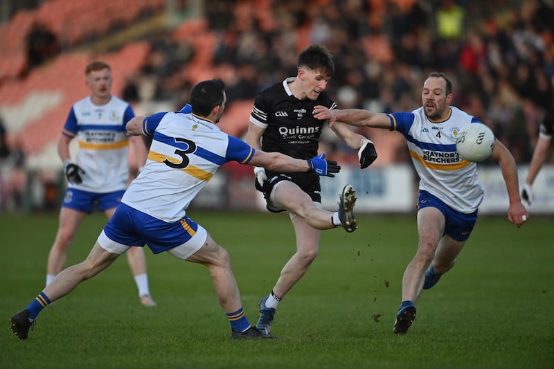 Miceal Rooney of Kilcoo getting his kick off against Aidan McCrory and Ciaran Quinn of Errigal Ciarán