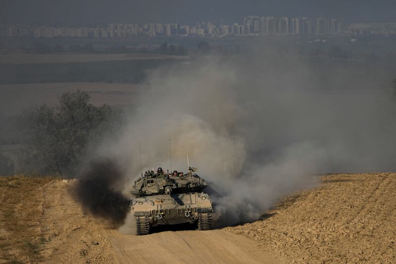 Israeli soldiers drive a tank near the Israeli-Gaza border (Tsafrir Abayov/AP)