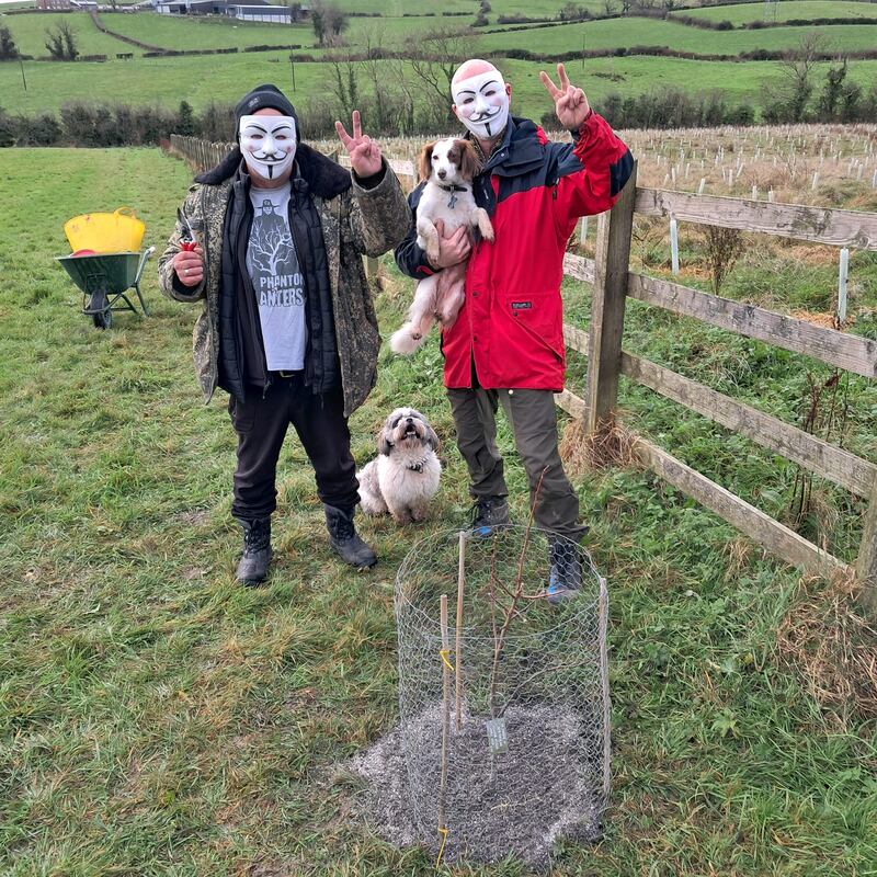 The Phantom and a project team member with one of their memorial apple trees. Picture: Phantom Planter/Facebook