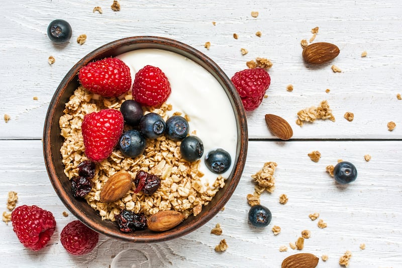 bowl of oat granola with yogurt, fresh raspberries, blueberries