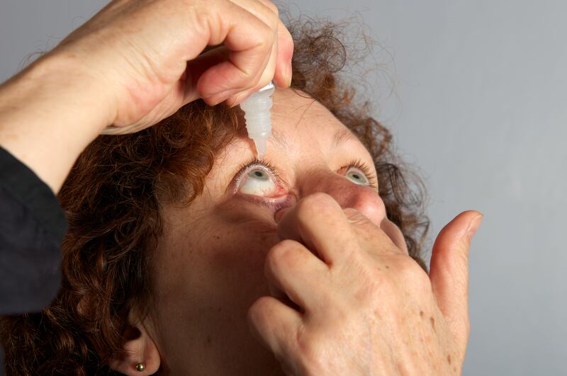 D9Y854 Hay fever sufferer using eye drops