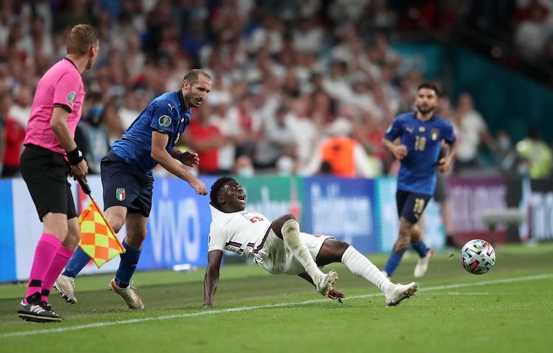 Italy’s Giorgio Chiellini (left) pulls back England’s Bukayo Saka during the Euro 2020 final .