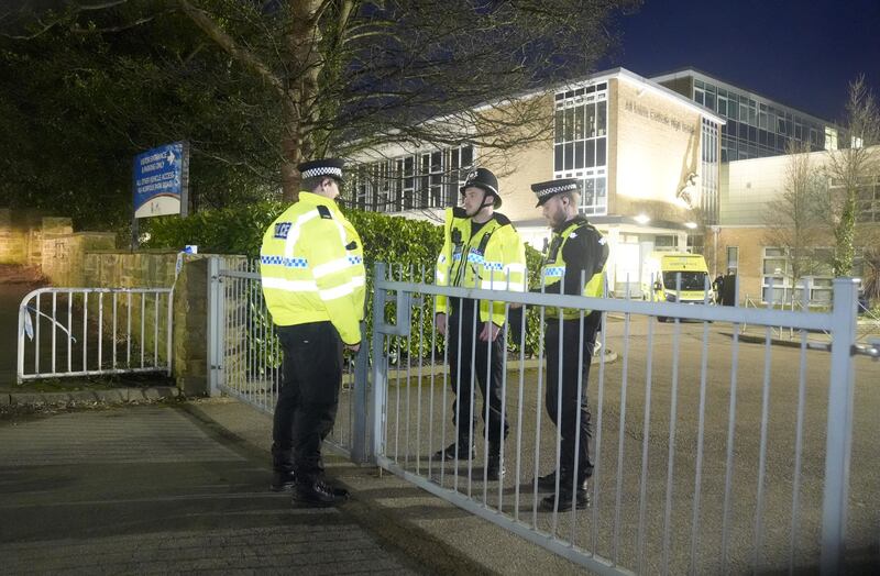 Police officers outside the school on Monday evening