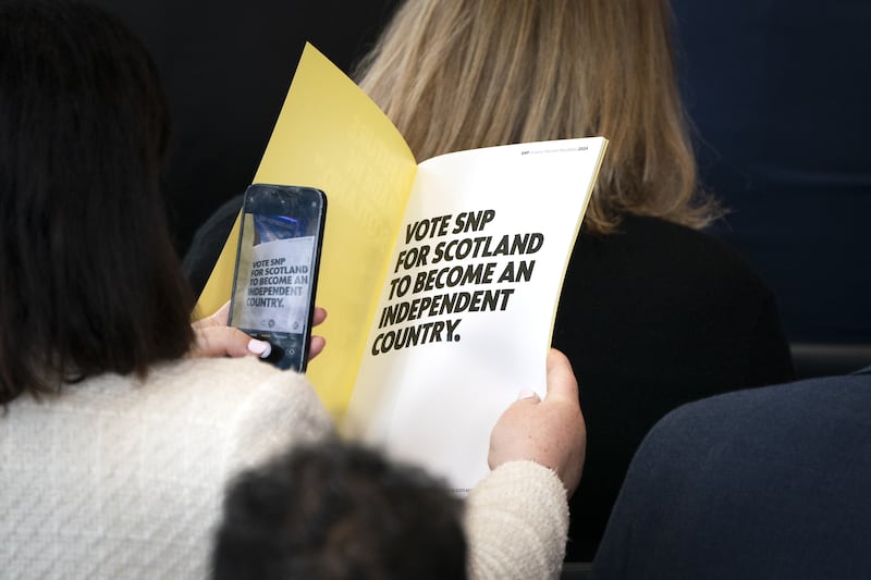 A delegate takes a picture of the first page of the SNP manifesto – where the party vows a vote for it is a vote for independence