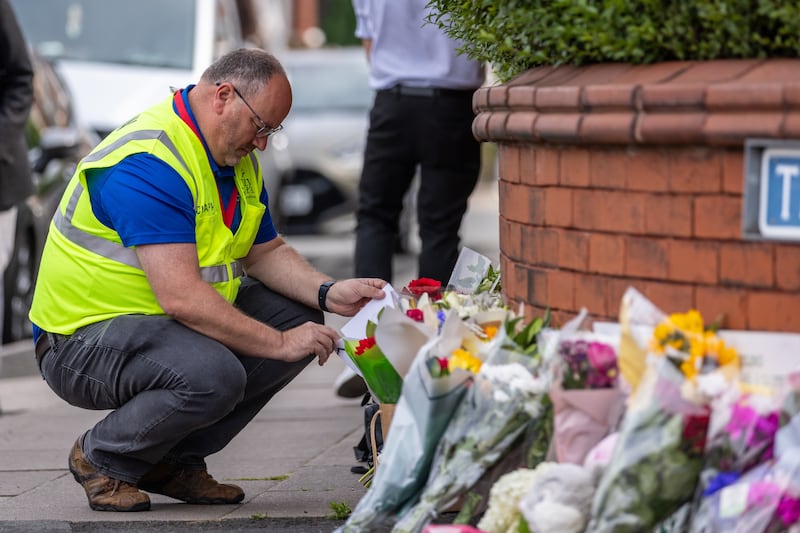 A man leaves flowers near the scene in Hart Street, Southport, where two children died and nine were injured in a ‘ferocious’ knife attack