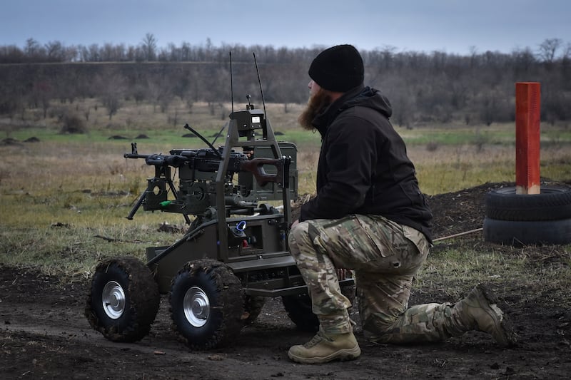 A Ukrainian serviceman demonstrates a Gnom 2 ground drone in the Zaporizhzhia region (Andriy Andriyenko/Ukraine’s 65th Mechanised Brigade/AP)