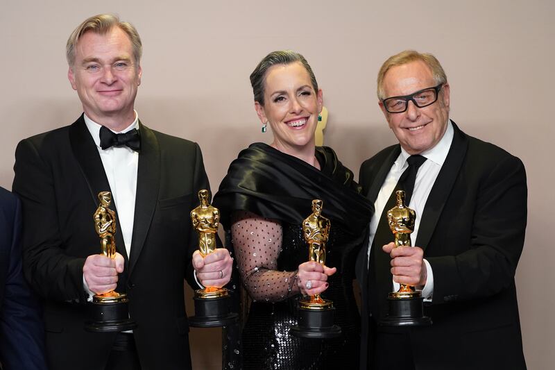 Christopher Nolan, winner of the award for best director for Oppenheimer, from left, Emma Thomas, and Charles Roven, pose in the press room with the award for best picture for Oppenheimer at the Oscars