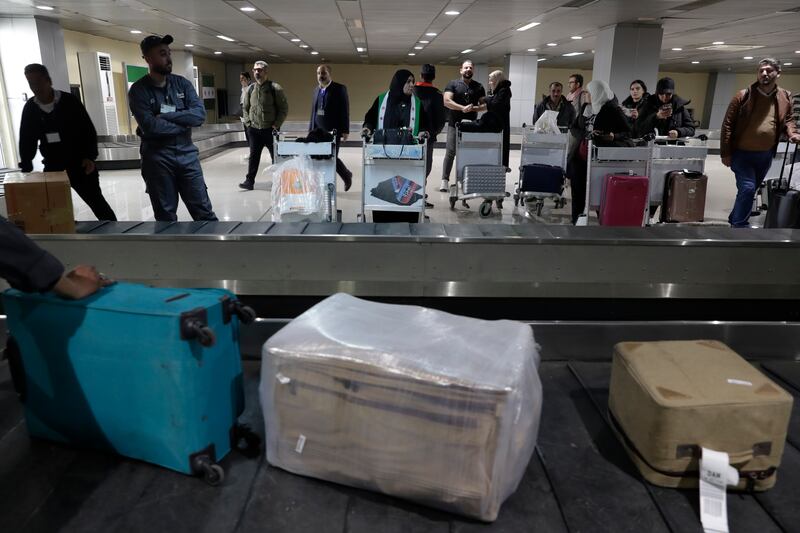 Passengers who arrived on the fight wait to receive their luggage (Omar Sanadiki/AP)